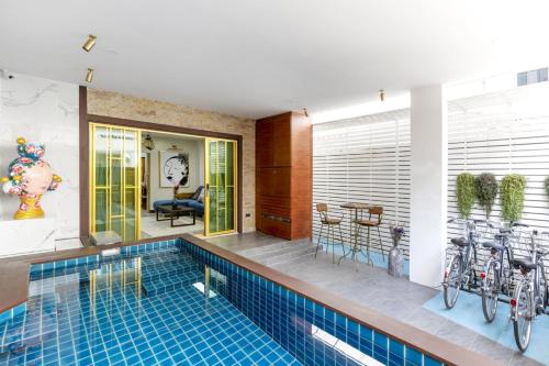 a house with a swimming pool with bikes in it at 4BR Luxury Pool Villa Siri Craft House Nimman in Chiang Mai