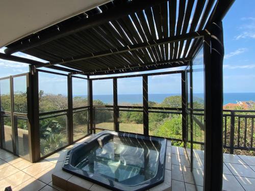 ヒバーデーンにあるHibberdene Holiday Homeの海が見えるバルコニーのホットタブ