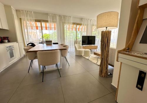 une cuisine et un salon avec une table et des chaises dans l'établissement Pointe Croisette, Palais & Palm Beach à pied, à Cannes