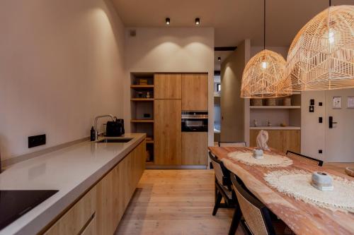 a large kitchen with a large wooden table and chairs at BTFL Living Antwerp in Antwerp