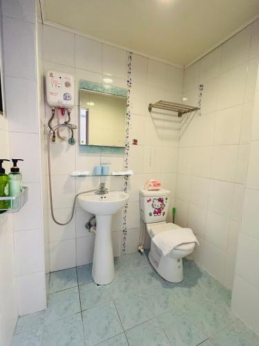 a bathroom with a sink and a toilet at Rowan House in Taichung