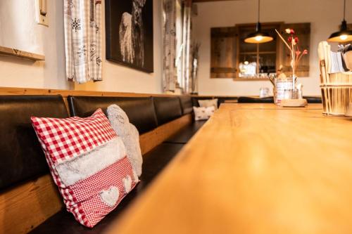 a wooden table with a red and white pillow on it at Gasthaus Amboss in Ravensburg