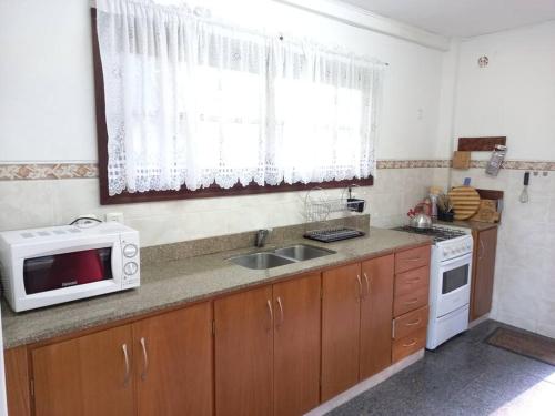a kitchen with a microwave and a sink at Chalet con baracoa in Punta del Este