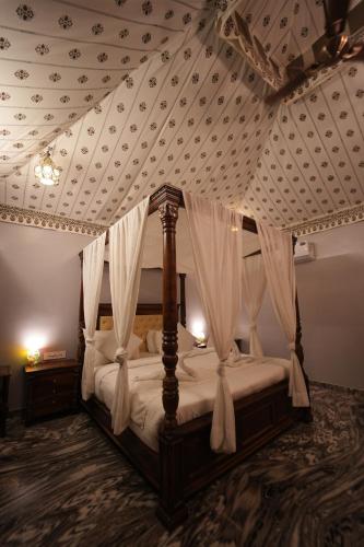 a bedroom with a canopy bed with a coffered ceiling at The Sky Imperial Nakoda Green Valley Resort in Nāthdwāra