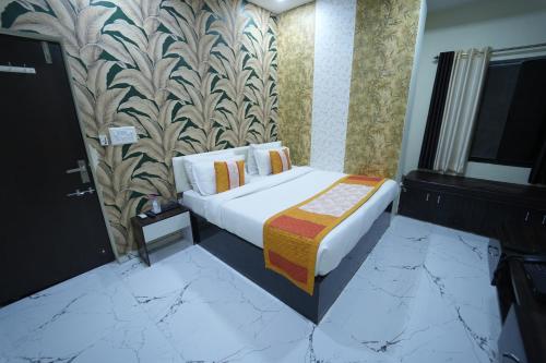a bedroom with a bed and a wall at The Sky Imperial Nakoda Green Valley Resort in Nāthdwāra