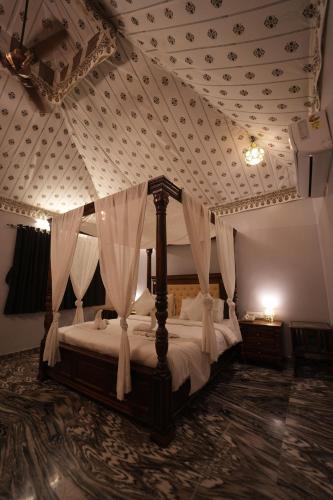 a bedroom with a canopy bed with a coffered ceiling at The Sky Imperial Nakoda Green Valley Resort in Nāthdwāra
