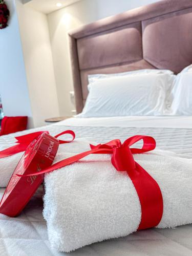 a bed with white towels and a red ribbon at Profumi di Primavera Luxury Rooms & Suite in Matera