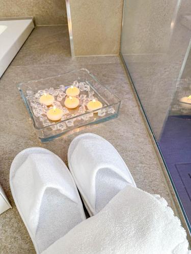 a pair of white shoes and a glass tray with candles at Profumi di Primavera Luxury Rooms & Suite in Matera