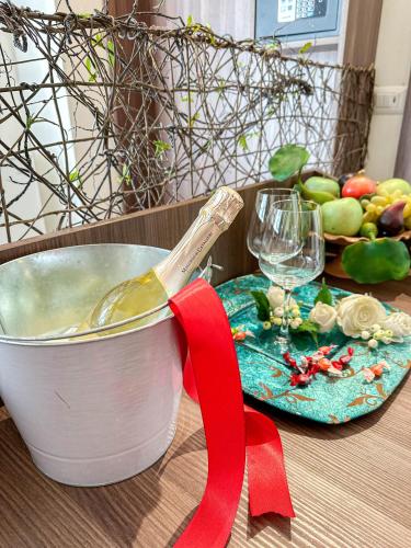 a cooking pot with a wooden spoon on a table with a glass of wine at Profumi di Primavera Luxury Rooms & Suite in Matera
