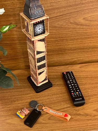a toy clock tower and a remote control on a table at Estúdio Alpes in Domingos Martins