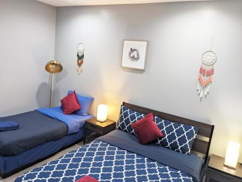 a bedroom with two beds and two lamps and a clock on the wall at Lucky Charm 4 Bedroom Mid-City Apartment in Los Angeles