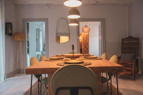 a dining room with a wooden table and chairs at Douro Bay House in Riba Douro