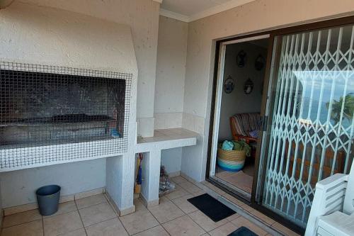 a living room with a fireplace and a patio at Die Ankers - Apartment 12 in Margate