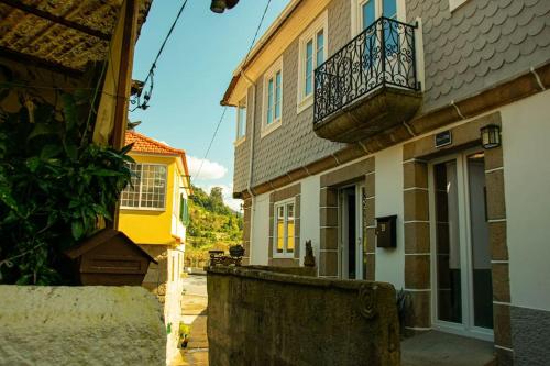 a building with a balcony on the side of it at Douro Bay House in Riba Douro