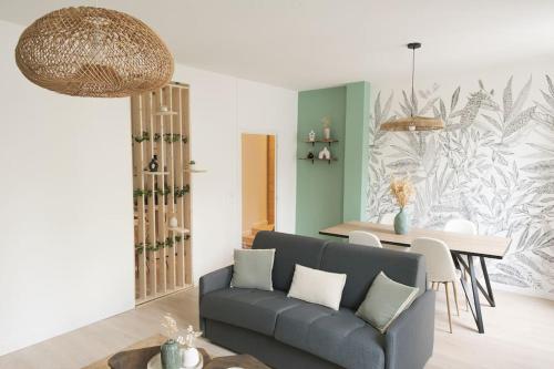 a living room with a couch and a table at THE COSY HOME Centre ville Parking Clim in Valence