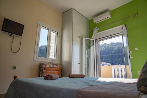 a bedroom with a bed and a large window at Katakolo Apartments near Olympia in Katakolon