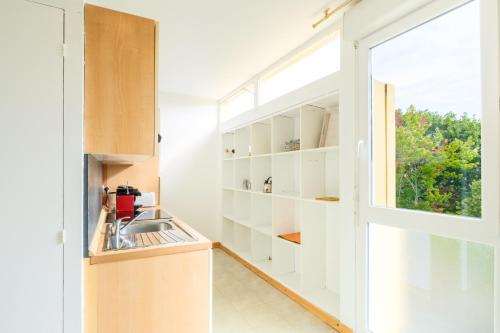 - une cuisine avec une fenêtre et un évier dans l'établissement Appartement charmant et cosy, à Biscarrosse