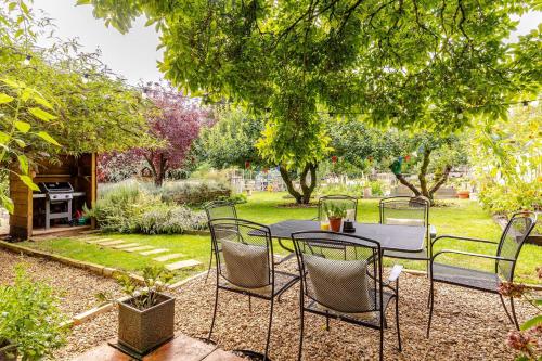 a patio with a table and chairs in a garden at Spacious Country Cottage Sleeps 7 Near Bath Fire Pit Dog Friendly in Bradford on Avon