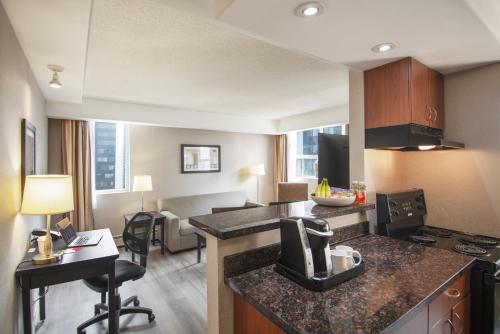 a room with a kitchen and a living room at Coast Calgary Downtown Hotel & Suites by APA in Calgary