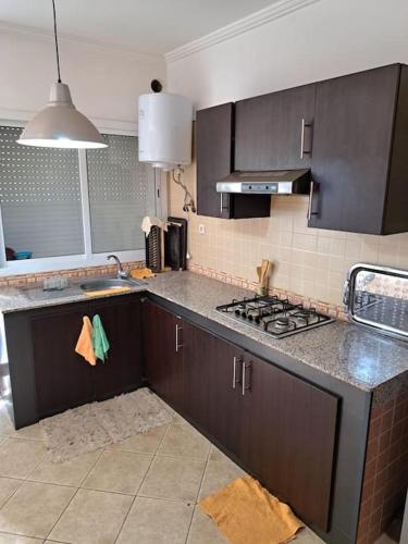 a kitchen with a sink and a stove top oven at Chalet Villa de Luxe - Piscine in Dchar Aït Belkassem