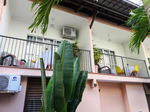 a man standing on the balcony of a house with a plant at Hotel Charme Fonte do Boi in Salvador