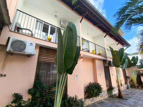 a house with a palm tree in front of it at Hotel Charme Fonte do Boi in Salvador