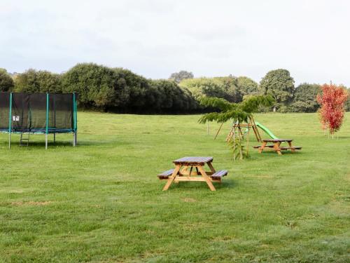 Saint-ÉvarzecにあるLa Ferme de Vur Venのピクニックテーブル2台、野原遊び場