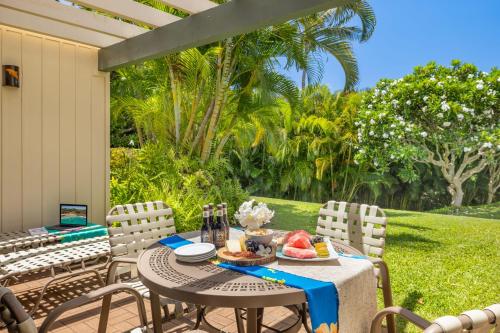 a table and chairs on a patio with food on it at Manualoha 303 in Koloa