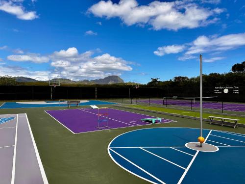 a tennis court with two benches on it at Manualoha 303 in Koloa