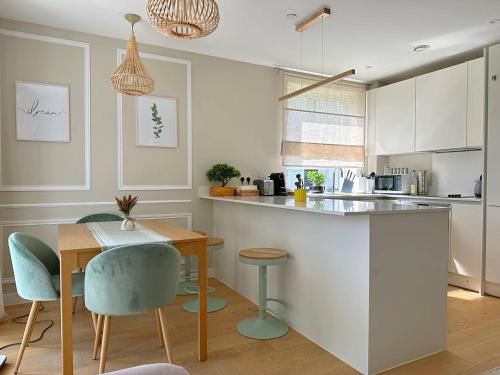 a kitchen with a table and chairs and a kitchen with white cabinets at Vick's house with parking and EV chrgr in Uxbridge