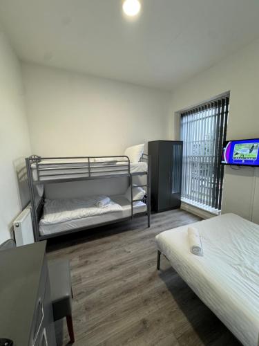 a room with two beds and a tv in it at Westgate Apartments in Newcastle upon Tyne