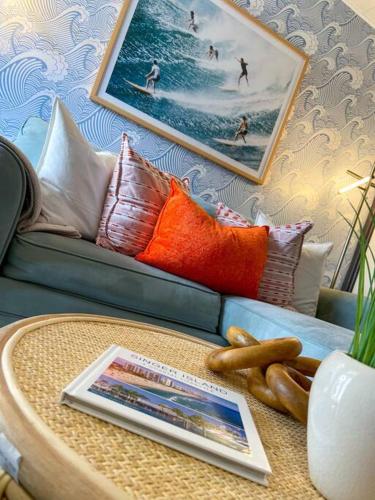 a living room with a couch and a table with a book at Cool Breeze Home -steps to the beach with Pool! in Riviera Beach