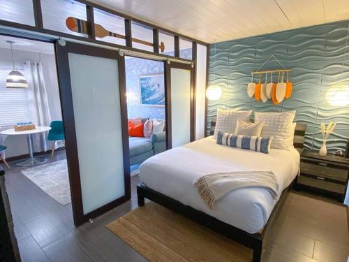 a bedroom with a large bed and a living room at Cool Breeze Home -steps to the beach with Pool! in Riviera Beach