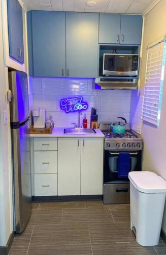 a small kitchen with a stove and a microwave at Cool Breeze Home -steps to the beach with Pool! in Riviera Beach