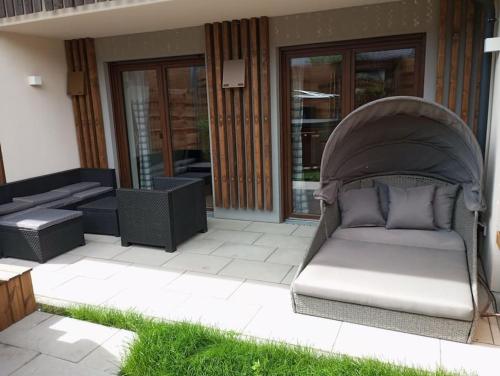 a couch sitting on a patio outside of a house at Wohnung Heuberg im Inntal mit Hot Tube - zentral & ruhig in Flintsbach am Inn