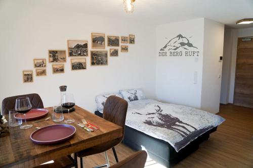 a room with a bed and a table and chairs at Wohnung Heuberg im Inntal mit Hot Tube - zentral & ruhig in Flintsbach am Inn