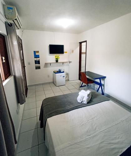 a hotel room with a bed and a desk in it at Ponta Negra Suites & Apart in Natal