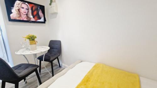 a bedroom with a bed and two chairs and a table at Private Garden Studio near London free Freeparking in West Thurrock