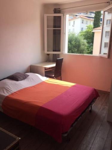 une chambre avec un lit, un bureau et une fenêtre dans l'établissement Nice port 4 pax, 2 chambres clim balnéo parking, à Nice