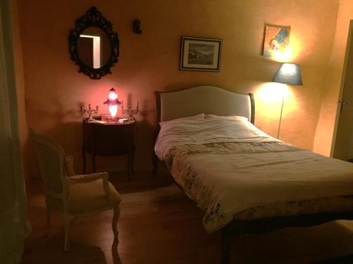 une chambre avec un lit et une table avec une lampe dans l'établissement Maison de village provençale, à Monieux