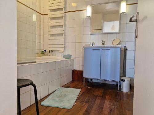 Elle comprend une petite salle de bains pourvue d'un lavabo et d'un comptoir. dans l'établissement Loft 80m2 Parking Vues magiques, à Paris