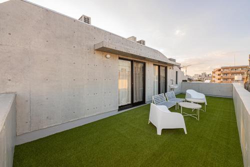 a balcony with chairs and a table and grass at 67 Apt Nishishinjuku Premium in Tokyo