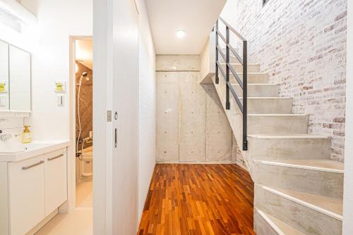 a bathroom with a staircase and a brick wall at 67 Apt Nishishinjuku Premium in Tokyo