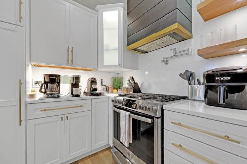 a kitchen with white cabinets and a stove top oven at Eugene Evergreen Escape By Leschaletsstays in Eugene
