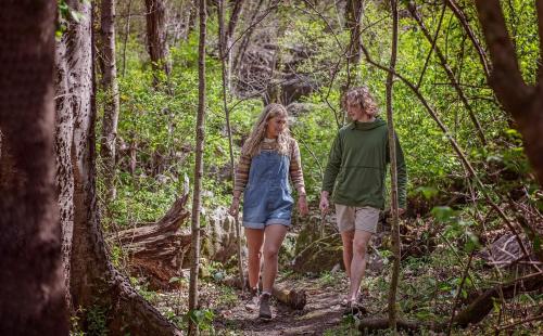 a man and a girl walking down a trail in the woods at Pops Cabin Lookout Mountain Luxury Tiny Home in Chattanooga