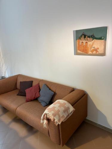 - un canapé brun avec des oreillers dans le salon dans l'établissement Portego mio, à Selvazzano Dentro