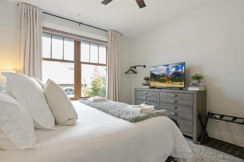 a bedroom with a bed with white pillows and a window at Franklin on Main in Blowing Rock