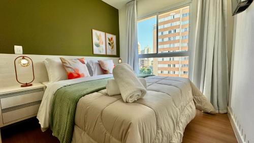 Un dormitorio con una cama grande con ventana. en Encantador 2 quartos do ladinho do Jardim Botânico By UROOMS, en Curitiba