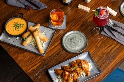 a wooden table with two plates of food and a drink at Hotel Indigo Denver Downtown - Union Station by IHG in Denver
