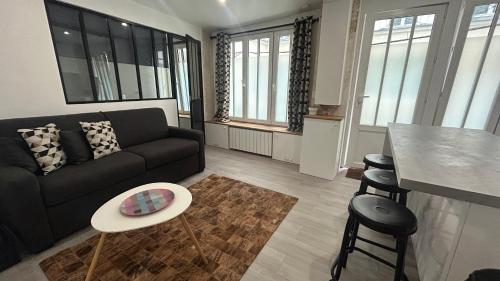 un salon avec un canapé et une table dans l'établissement Bel Appartement a 5 minutes du Louvre, à Paris